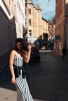 Beautiful fashionable lady posing on old street photo