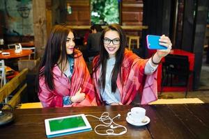 two close friends make selfie in the cafe photo