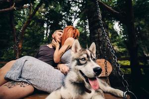hermosa pareja junto con un perro en un columpio foto