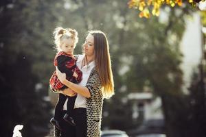 Mother and little daughter playing in a park photo
