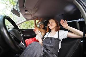 Young females on a road trip traveling by a car. photo