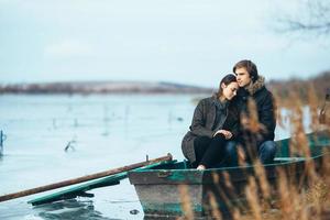 young beautiful couple on the ice of a frozen lake photo