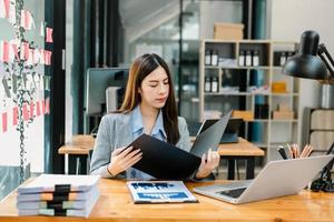 retrato de una mujer empresaria de oficina soñando despierta con su trabajo, puesta en marcha y trabajando con una computadora portátil en el escritorio de la oficina en la sala de oficina sentada en la cafetería foto