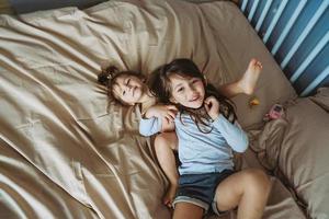 happy little girls lying on back top view sisters photo