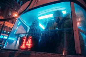 The guy and the girl kiss on the tram behind the misted glass photo