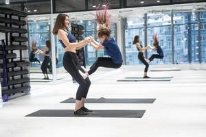 Young adult mother doing fitness with her little daughter photo