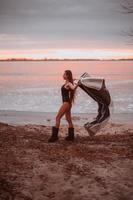 hermosa joven en traje de baño en la orilla de un lago congelado foto