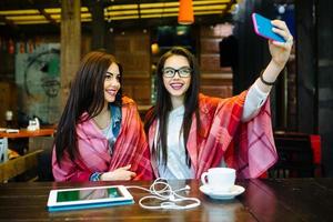 two close friends make selfie in the cafe photo