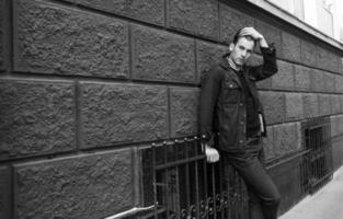 Male model in jeans on the background of a red wall photo