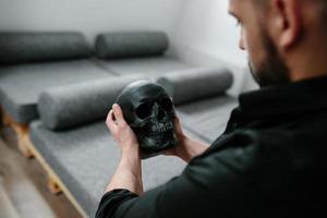 bearded man holding skull photo