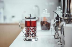 fresh berry tea in French press on the table photo