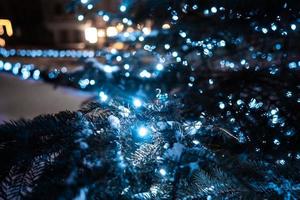 Christmas tree with cones on a city street illuminated with a garland. photo