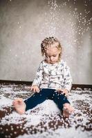 Little girl is playing with foam balls photo