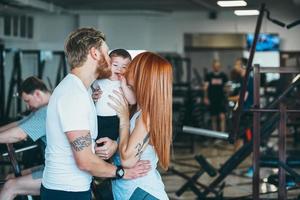 familia joven con niño pequeño en el gimnasio foto