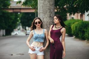 Two beautiful young girls posing in the city photo