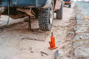 A man raises on a jack 4x4 off road truck photo