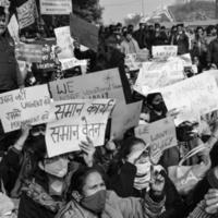 Delhi, India December 25 2021 - Delhi Contractual Guest Teachers with posters, flags and graffitis protesting against Delhi AAP Government for making policy, Delhi Teacher protesting Black and White photo