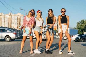 Four young girls have fun at the car park. photo