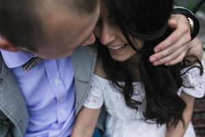 Young European couple cuddling on a park bench photo