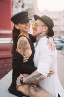 una joven y sexy pareja de amantes posan para una cámara en las calles foto