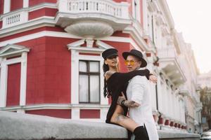 A young, sexy couple of lovers pose for a camera on the streets photo