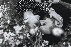 pareja joven se encuentra en el campo con margaritas. foto