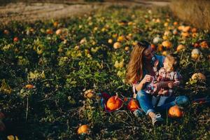 madre e hija en un campo con calabazas foto