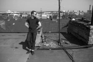 The man in the authentic boots and jeans selvedge on the roof of the building in the old town photo