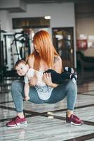 joven madre con su hijo pequeño en el gimnasio foto