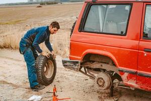 Man change the wheel manually on a 4x4 off road truck photo
