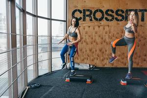 Two beautiful girls together in a fitness room photo