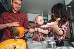 Dad, mom and little son cook a pie photo