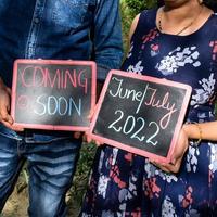 pareja india posando para una sesión de fotos de maternidad. la pareja está posando en un césped con hierba verde y la mujer está faluntando su panza en el jardín lodhi en nueva delhi, india