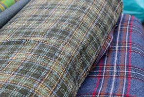 Detailed close up view on samples of cloth and fabrics in different colors found at a fabrics market photo