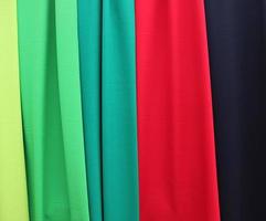 Detailed close up view on samples of cloth and fabrics in different colors found at a fabrics market photo