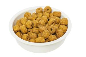 Dry food for dogs or cats in a white bowl isolated on a white background. Food is good for animals. photo