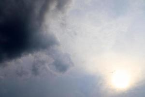 hermosa vista a los rayos de sol con algunas bengalas y nubes en un cielo azul foto