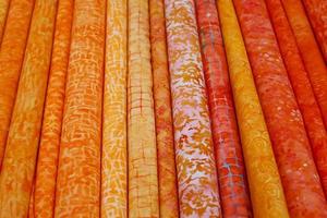 Detailed close up view on samples of cloth and fabrics in different colors found at a fabrics market photo