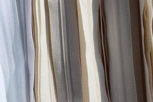 Detailed close up view on samples of cloth and fabrics in different colors found at a fabrics market photo