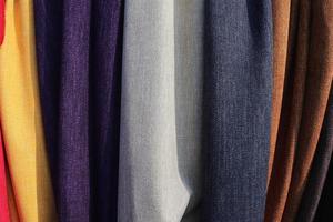 Detailed close up view on samples of cloth and fabrics in different colors found at a fabrics market photo