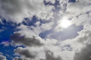 Beautiful view at sunbeams with some lens flares and clouds in a blue sky photo