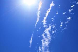 Beautiful view at sunbeams with some lens flares and clouds in a blue sky photo