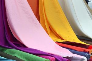 Detailed close up view on samples of cloth and fabrics in different colors found at a fabrics market photo