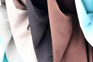 Detailed close up view on samples of cloth and fabrics in different colors found at a fabrics market photo
