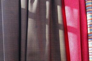 Detailed close up view on samples of cloth and fabrics in different colors found at a fabrics market photo