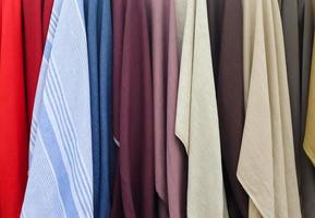 Detailed close up view on samples of cloth and fabrics in different colors found at a fabrics market photo