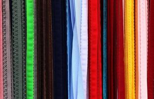 Detailed close up view on samples of cloth and fabrics in different colors found at a fabrics market photo