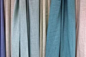 Detailed close up view on samples of cloth and fabrics in different colors found at a fabrics market photo