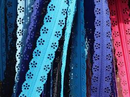 Detailed close up view on samples of cloth and fabrics in different colors found at a fabrics market photo