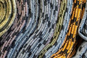 Detailed close up view on samples of cloth and fabrics in different colors found at a fabrics market photo